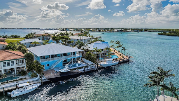 A waterfront property with a pool, boats, and a dock. - Key Colony Beach Waterfront 6BR w/ Pool & Dock (Key Colony Beach)
