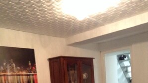Ein Zimmer mit einem Holzkasten, einem Stuhl und einem Gemälde an der Wand.