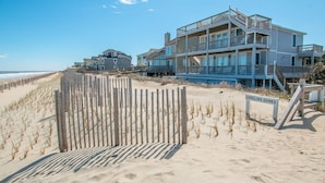 A beachfront property with a wooden boardwalk leading to a sign reading "CAROLINA DUNES." - 2875 - MOJO'S, Duck Beachfront Home w/ Pool Table & Views (Duck)