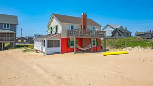 A beach house with a wooden deck and a hammock. - 5452- Sea Captain's Cottage - Historic Oceanfront Cottage | Nags Head (Nags Head)