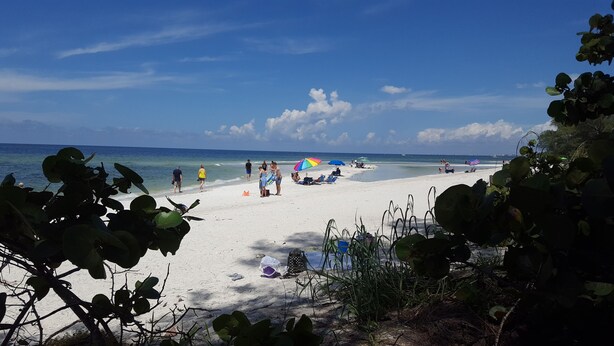 A beach with people, umbrellas, and beach chairs. - Stunning Naples home with pool, bike to the Gulf at Wiggins or Vanderbilt.  (Naples)