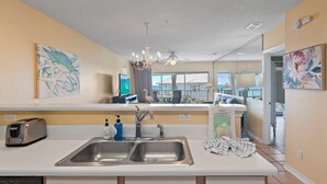 Una cucina moderna con un lavello doppio, un tostapane e una ventola a soffitto.