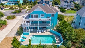 A large two-story house with a swimming pool, a balcony, and a view of the ocean. - 1600 - Bases Loaded - Spacious Buck Island Retreat in Corolla (Corolla)