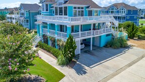 A multi-story residential building with balconies and a covered patio area. - 1600 - Bases Loaded - Spacious Buck Island Retreat in Corolla (Corolla)