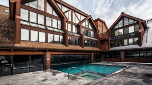 Un bâtiment moderne doté de grandes fenêtres et d’une piscine.