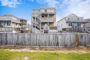 Il s'agit d'une propriété située en bord de mer, comprenant plusieurs bâtiments en bois, chacun doté de balcons et d'escaliers menant aux étages supérieurs.