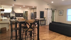 Una cocina moderna con una isla central, una mesa de comedor de madera y sillas.