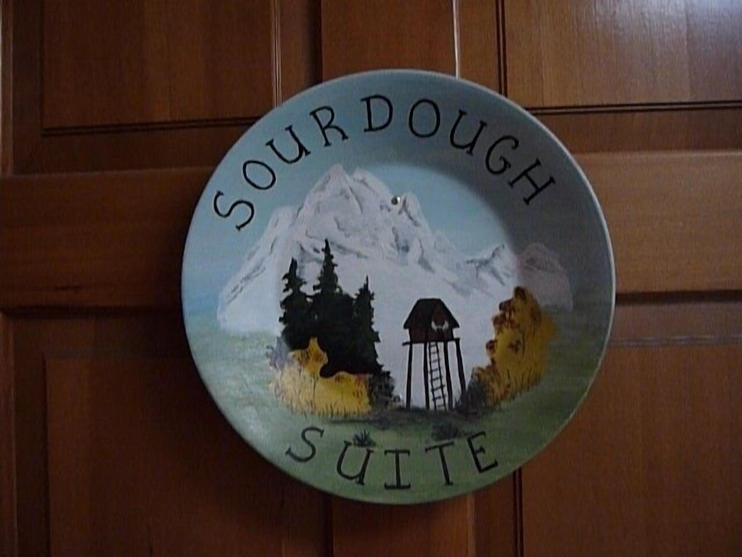 Un plato con el texto 'Sourdough Suite' y una escena de montaña.