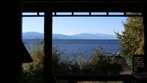 A view from a window overlooking a body of water with mountains in the distance.