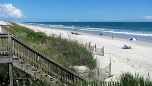 A beach with a wooden boardwalk leading to the shore, sandy beach, and ocean. - Gorgeous 4 BR/4 BA Top Floor Front Row Islander Villa (Ocean Isle Beach)