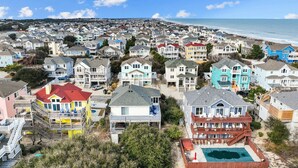 A coastal residential area with colorful houses, a beach, and a swimming pool. - 1781 - Brownie's Retreat, 53 Yards to Beach! Oceanside w/ Private Hot Tub (Corolla)