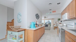 Una cocina moderna con armarios de madera, una isla central y una zona de comedor con sofá.
