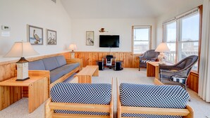A cozy living room with wooden furniture, a flat-screen TV, and artwork on the walls. - 6285-Tidal Song, | Oceanside | South Nags Head | Sleeps 8 (Nags Head)