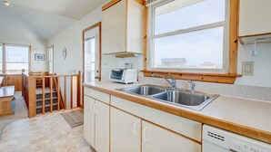A modern kitchen with a wooden countertop, stainless steel sink, and white cabinets. - 6285-Tidal Song, | Oceanside | South Nags Head | Sleeps 8 (Nags Head)