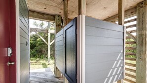 A wooden deck with a door and a window. - 6285-Tidal Song, | Oceanside | South Nags Head | Sleeps 8 (Nags Head)
