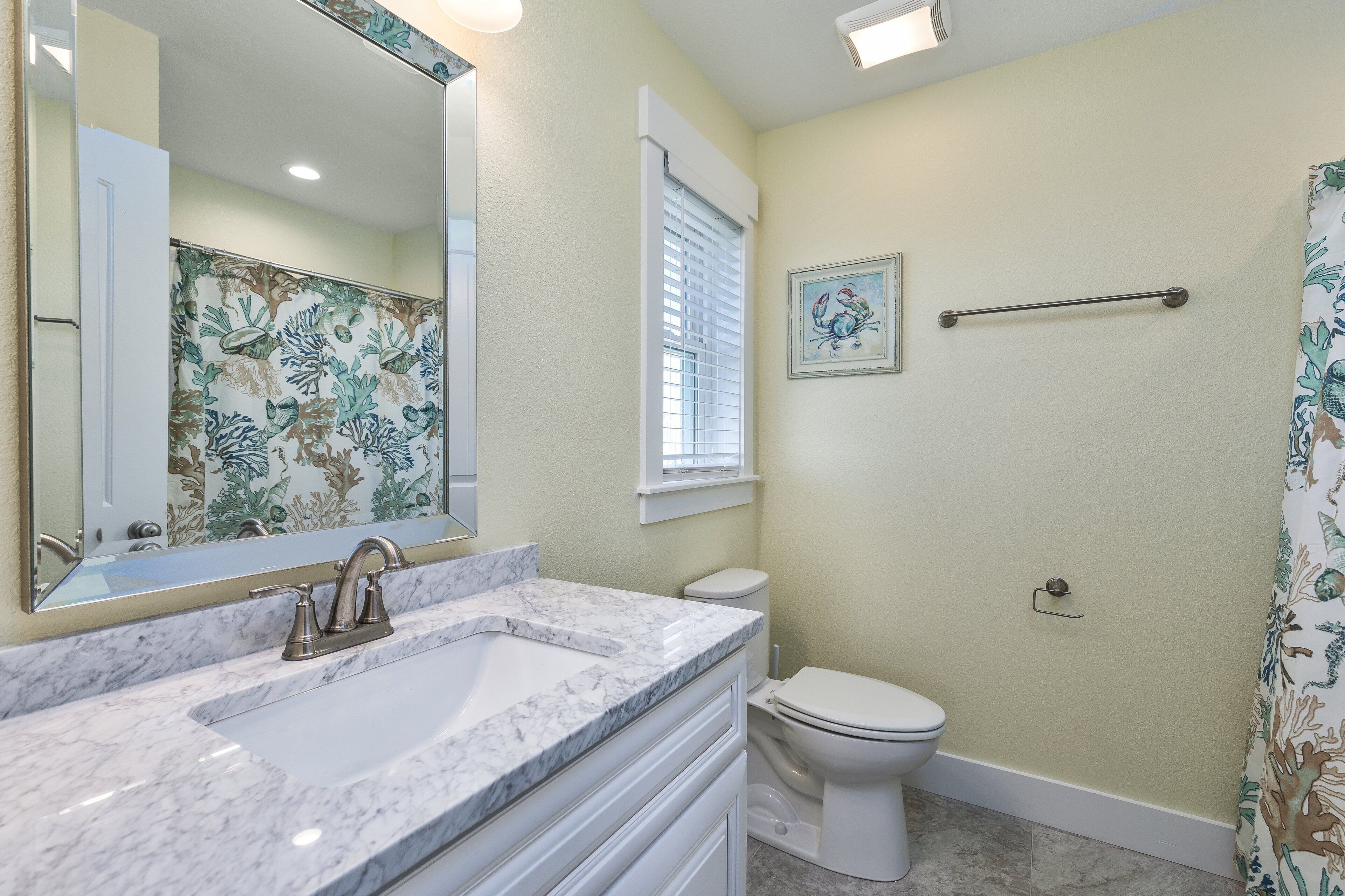 Une salle de bain avec un lavabo blanc, des toilettes et un rideau de douche.