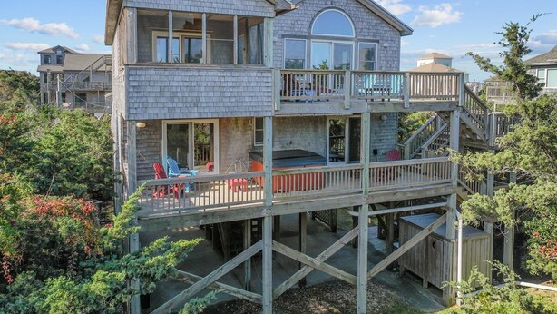 Een huis met twee verdiepingen, een balkon en een terras.