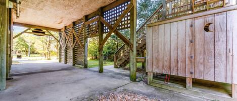 An open wooden structure with a concrete floor, wooden beams, and a lattice wall.