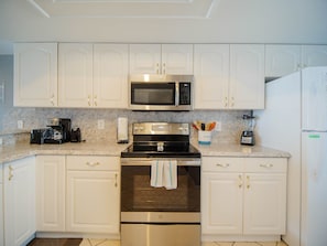 Enjoy cooking in this fully equipped kitchen with a microwave, coffee maker, toaster, and refrigerator.