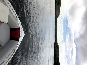 Un barco sobre aguas tranquilas, con un paisaje montañoso al fondo.