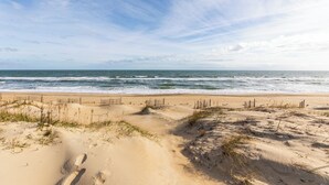 A sandy beach with gentle waves and a clear sky.