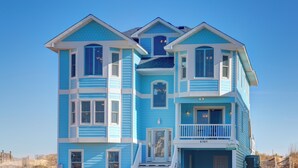 A two-story house with a balcony, a front door, and a mailbox.