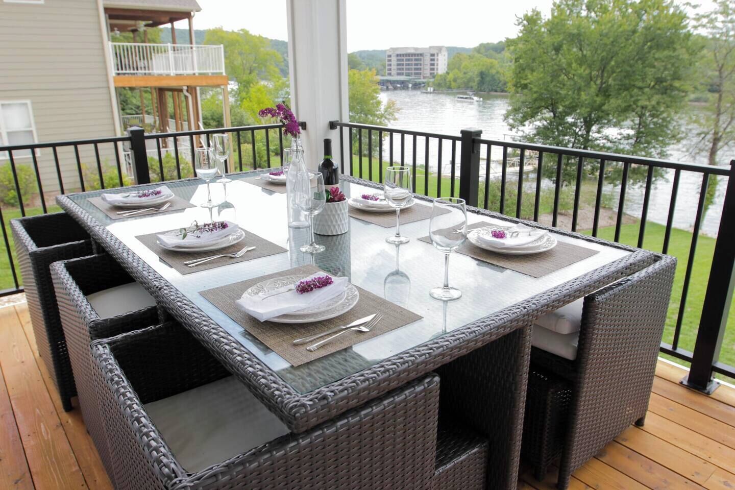A dining table set for four with a view of a river and buildings in the background.