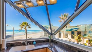 Eine Küche mit einem großen Fenster mit Blick auf einen Strand.