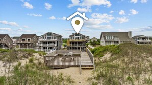 A beachfront property with multiple houses connected by a wooden walkway. - 5785- Southern Comfort - South Nags Head Oceanfront Retreat (Nags Head)