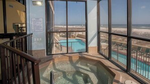 A hot tub with a view of a beach and a pool.