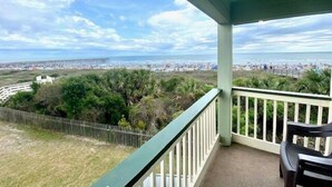 A balcony with a view of a beach and pier.