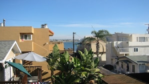 A residential area with houses, a clear sky, and a body of water in the background. - 3 bdr, 3 bath Home  Walk to bay, ocean, restaurants and shops! (San Diego)