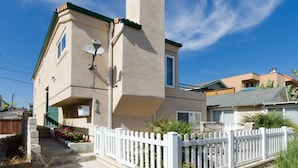 A two-story house with a white picket fence, a satellite dish, and a small porch area. - 3 bdr, 3 bath Home  Walk to bay, ocean, restaurants and shops! (San Diego)