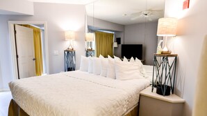 Una habitación de hotel con una cama grande, televisión y dos lámparas.