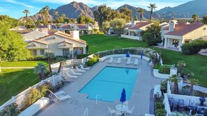 A resort with a swimming pool, lounge chairs, and a view of mountains. - Desert Luxe | 3BR Santa Rosa Cove (La Quinta)