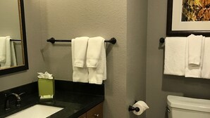 Een badkamer met een wastafel, spiegel, handdoekhouder, toilet en een lijstwerk aan de muur.