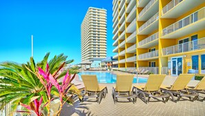 Un espace piscine d’hôtel avec des chaises longues et une vue dégagée sur la piscine.