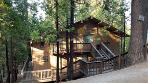 A cabin with a wooden deck, multiple balconies, and a staircase leading to the upper levels. - PinecrestAreaRentals #17  Fun cabin Summer 3rd night free. Just Book 2nights. (Cold Springs)