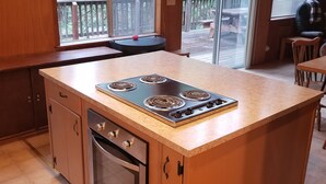 A kitchen with a large island, built-in oven, and a view of the deck. - PinecrestAreaRentals #17  Fun cabin Summer 3rd night free. Just Book 2nights. (Cold Springs)