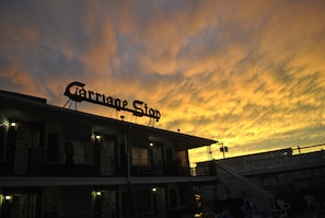 Experience the charm of Carnival Stop, a building with a flat roof and upper-level balcony.