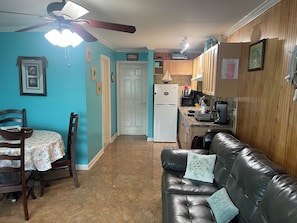 Cozy living space with a kitchenette, dining table, and comfortable sofa.