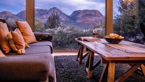 A cozy room with a sofa, a wooden table, and a bowl of snacks. - The Loft - Freycinet Holiday houses (Coles Bay)