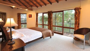 A bedroom with a bed, a chair, and large windows with curtains. - Risehill House
House among tree tops, tranquil and cosy feel. Magnificent views. (Kalorama)