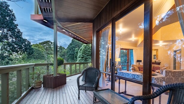 A wooden deck with wicker furniture, a view of the outdoors, and a glimpse of the interior with a sofa and table. - Risehill House
House among tree tops, tranquil and cosy feel. Magnificent views. (Kalorama)