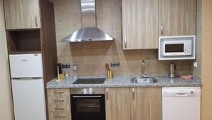A kitchen with wooden cabinets, a stainless steel range hood, a microwave, a sink, and a dishwasher. - House Tradition Rural for 16-20 people (Nieva)