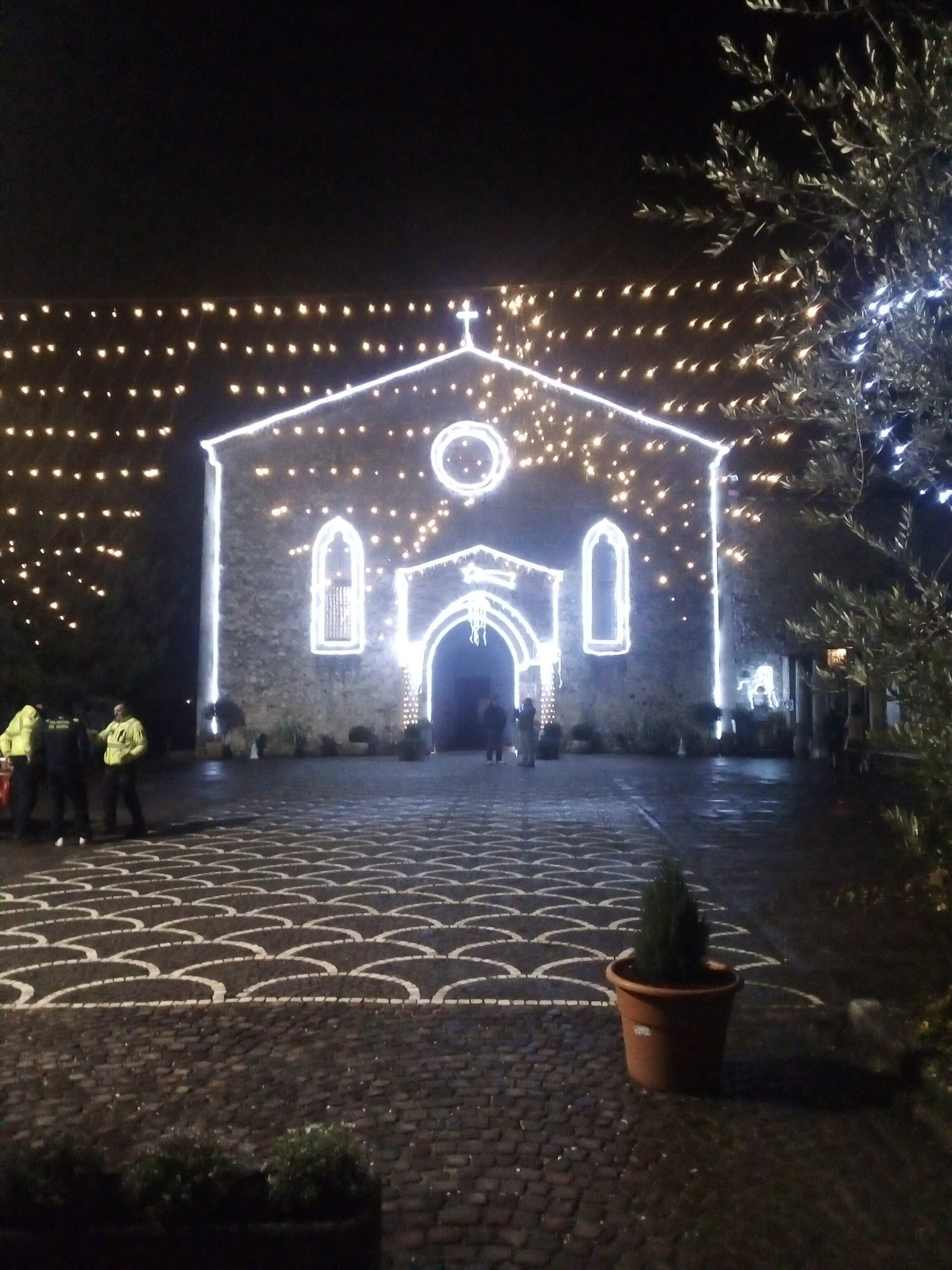 Edifício com entrada decorada, rodeado por luzes de Natal.