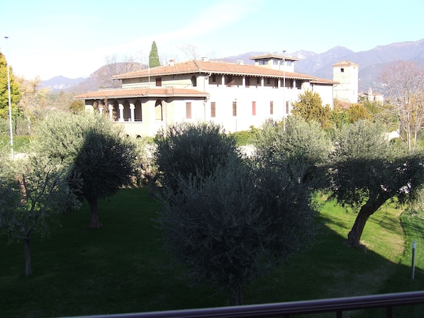 A building with a courtyard, surrounded by trees and mountains in the background.
