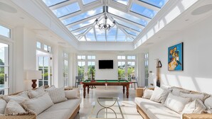 A spacious room with a pool table, two sofas, a glass coffee table, and a large painting on the wall. - Coedrath House - Luxury Manor, Swim Spa, Sea Views (Saundersfoot)