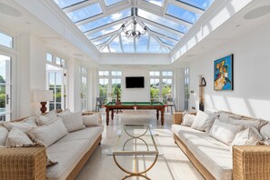 A spacious room with a pool table, two sofas, a glass coffee table, and a large painting on the wall. - Coedrath House - Luxury Manor, Swim Spa, Sea Views (Saundersfoot)