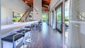 A modern kitchen with a long countertop, stainless steel appliances, and a staircase leading to an upper level. - Beautiful private villa with hot tub, A/C, private pool, WIFI, TV, terrace and pets allowed (Pazin)